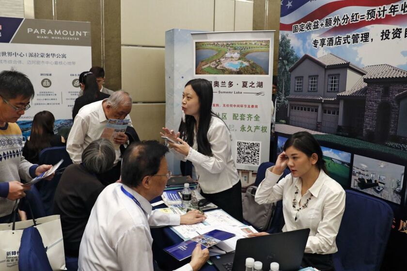 Visitantes chinos buscan información sobre el programa de visas EB-5, del gobierno de los EE.UU., en una cumbre de inversión realizada en Beijing, en 2017 (Andy Wong / Associated Press).