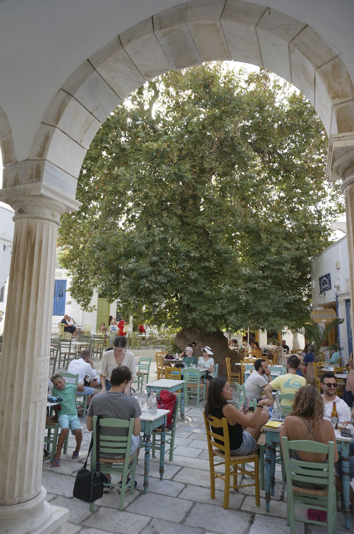A large plane tree shades the cafe-lined central square in the village of Pyrgos on Tinos, which is paved with marble.