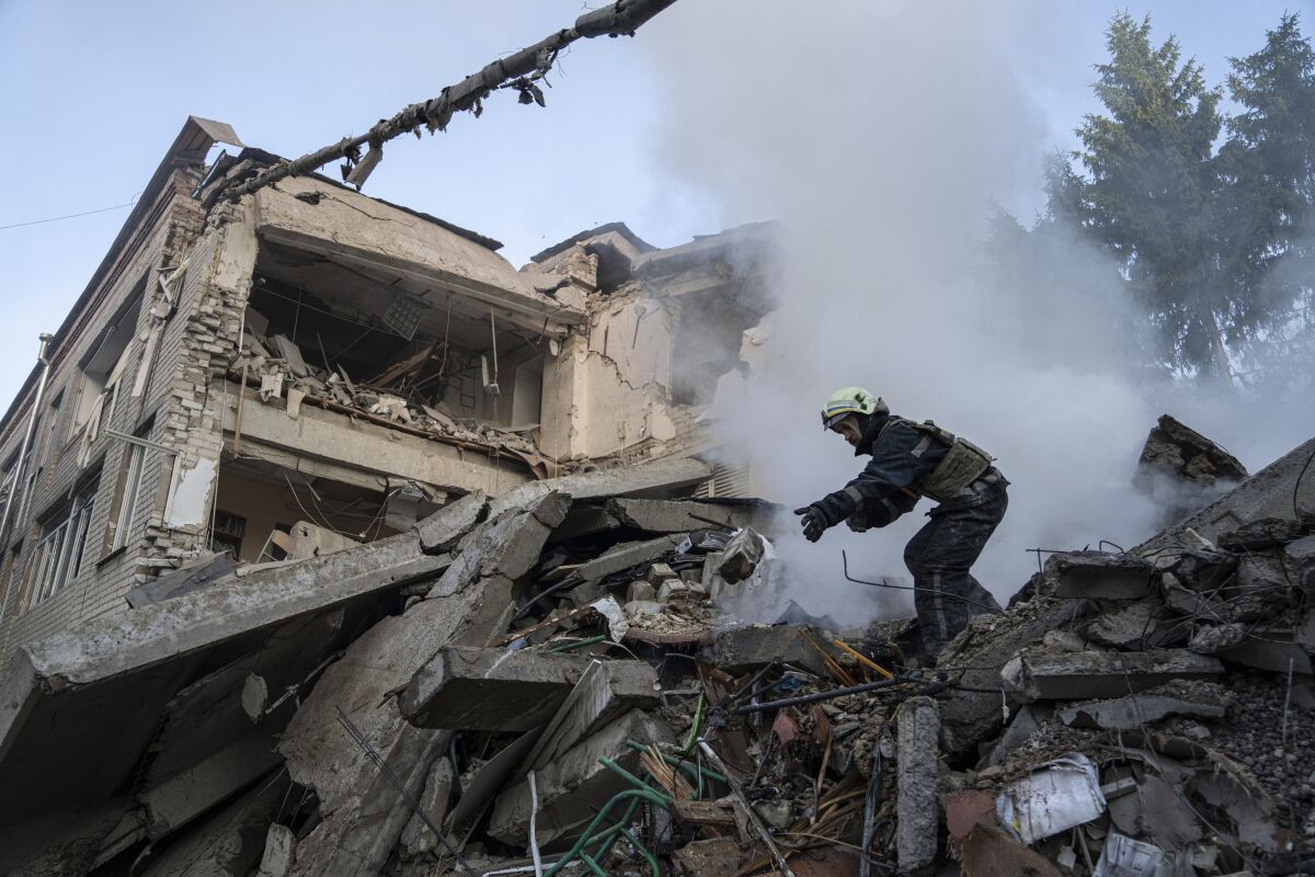 Worker cleaning out rubble from a destroyed school in Kharkiv, Ukraine