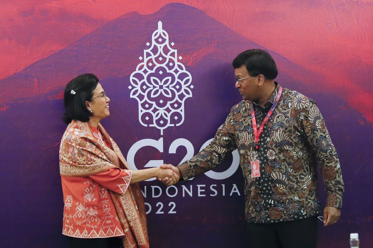 Indonesian Finance Minister Sri Mulyani Indrawati, left, shakes hands with Financial Action Task Force (FATF) President Raja Kumar during their bilateral meeting on the sidelines of the G20 Finance Ministers and Central Bank Governors Meeting in Nusa Dua, Bali, Indonesia, Saturday, July 16, 2022. (Made Nagi/Pool Photo via AP)