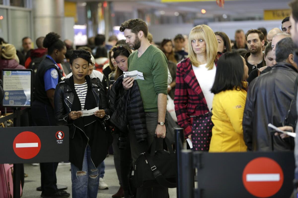 Passengers wait in line to clear security at LaGuardia Airport in New York.