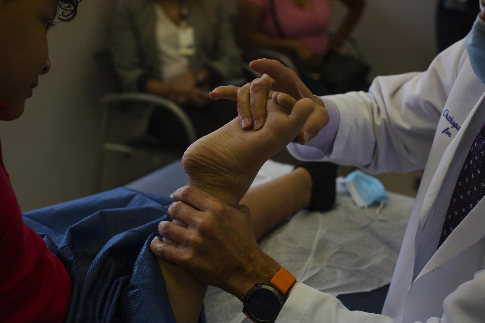 A doctor examines Efraín's foot 