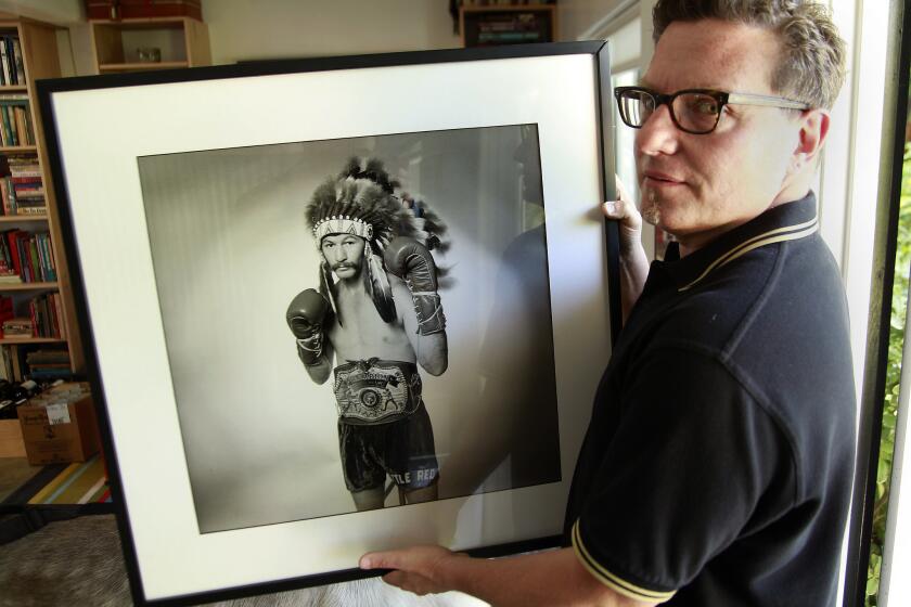 Steve DeBro has collected a mass of memorabilia while making the forthcoming documentary "18th & Grand" about Los Angeles' Olympic Auditorium. Here he holds a photo of boxer Danny Lopez.