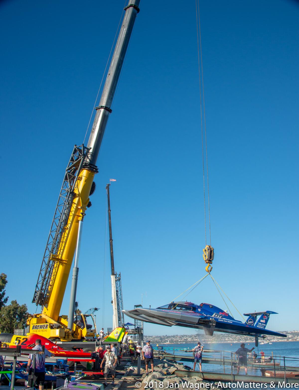 Giant crane lifts a hydroplane as the salt water is washed off.