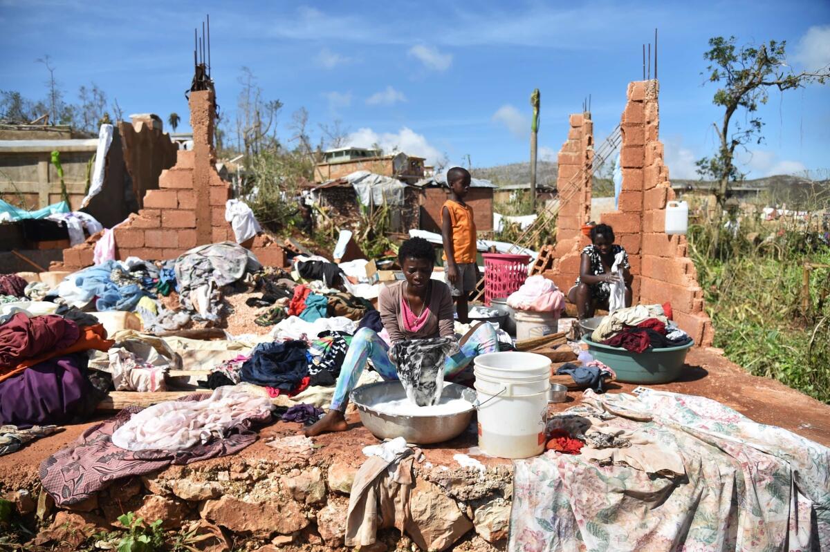 A woman washes clothes in the middle of a home destroyed by Hurricane Matthew in the village of Casanette, Haiti, on Oct. 8.