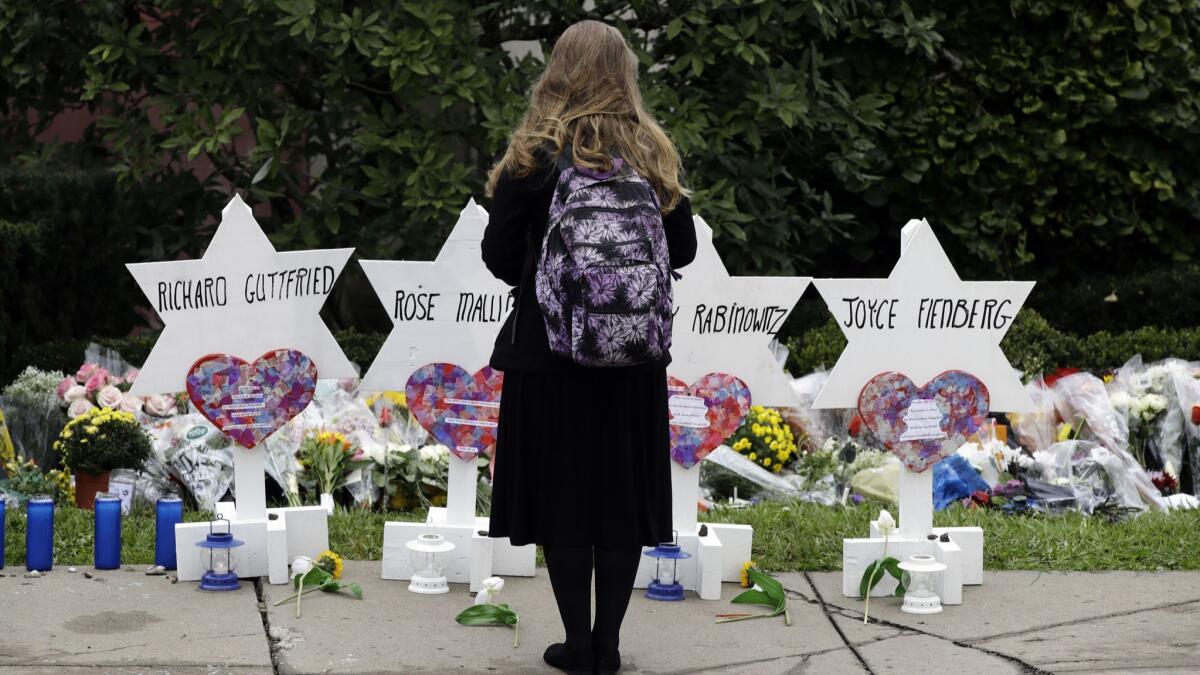 A person stands in front of Stars of David that are displayed in front of the Tree of Life Synagogue with the names of those killed in Saturday's deadly shooting in Pittsburgh.