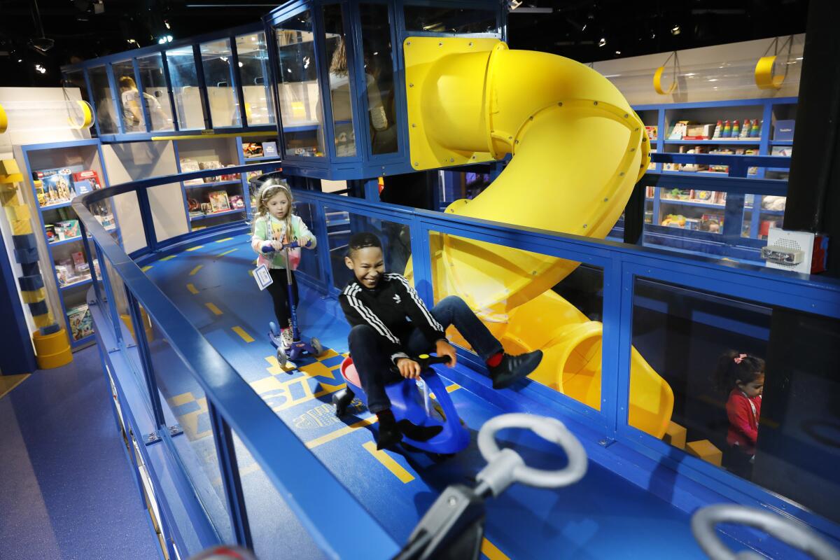 Children ride scooters at a Camp toy store