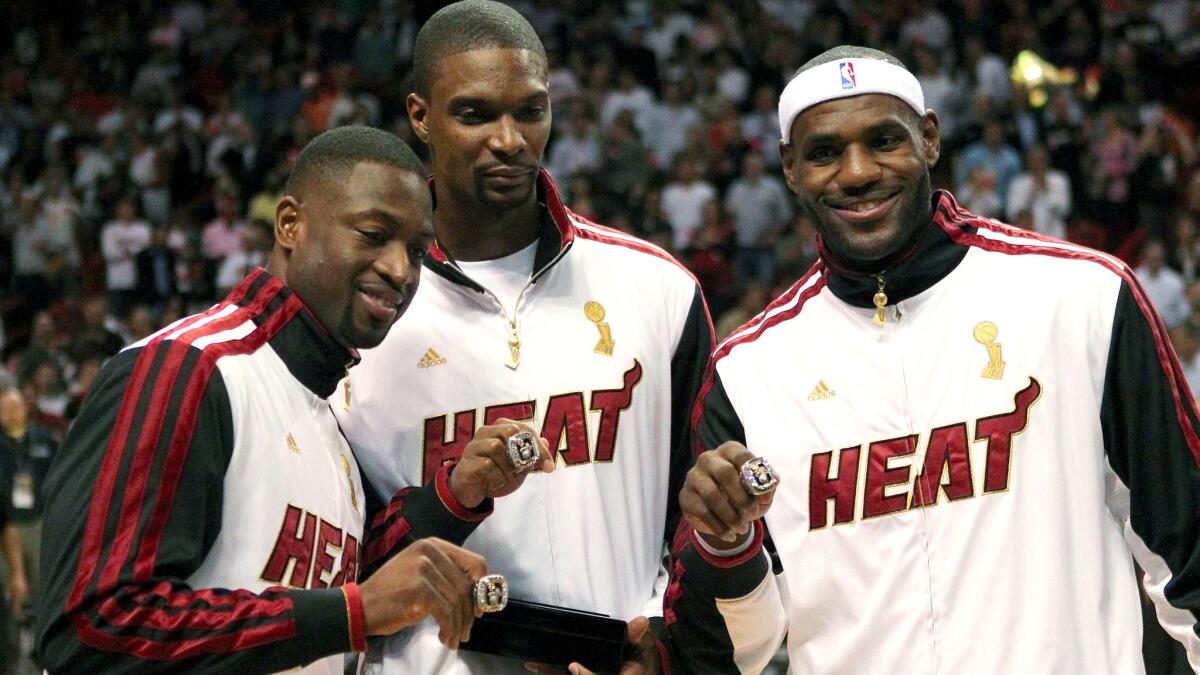 Miami Heat teammates Dwyane Wade, left, Chris Bosh, center, and LeBron James pose with their 2012 championship rings before a game against the Boston Celtics in Oct. 2012. It appears the trio could be heading for a breakup this off-season.