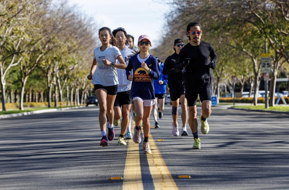 Evan Kim, 12, front, runs with family members and a running group to train for marathons.