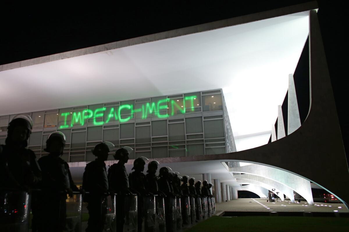 Soldiers stand guard outside Planalto presidential palace, where protesters projected the word "Impeachment" on the building.