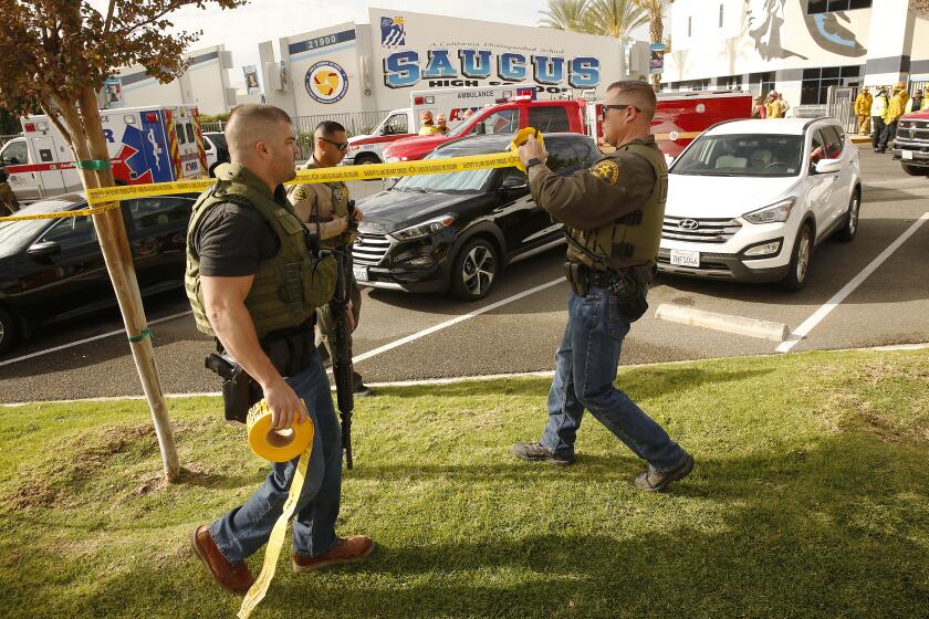 SAUGUS, CA - NOVEMBER 14, 2019 Police officers cordon off Saugus High School after at least six people were wounded in a shooting at Saugus High School when a gunman opened fire on the Santa Clarita campus early Thursday. (Al Seib / Los Angeles Times)