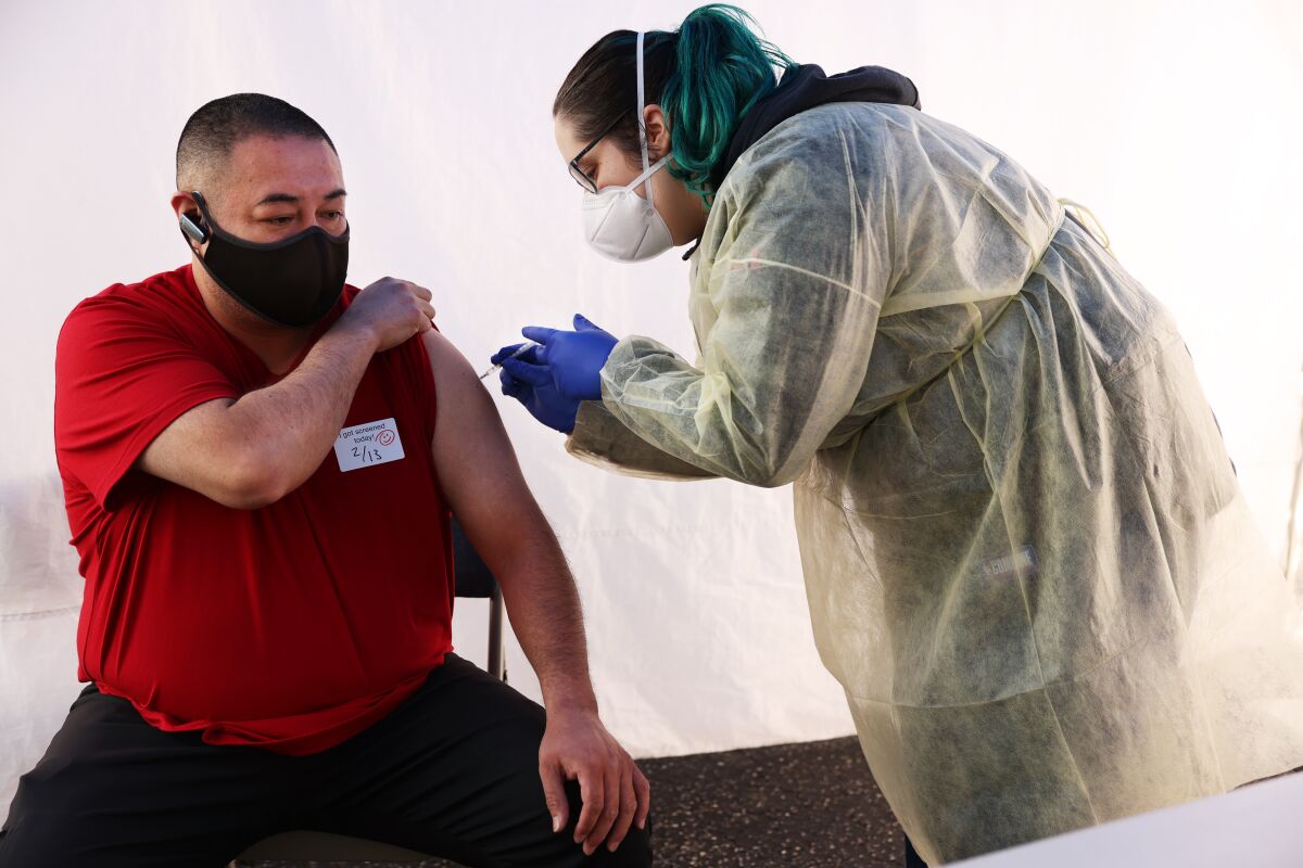 A healthcare worker administers a shot.