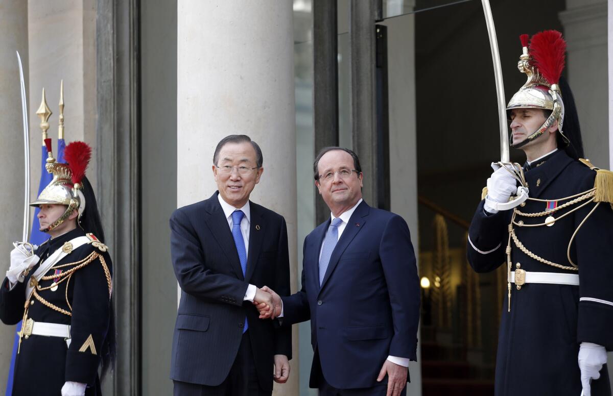 U.N. Secretary-General Ban Ki-moon, center left, is greeted by French President Francois Hollande at the Elysee Palace, in Paris.