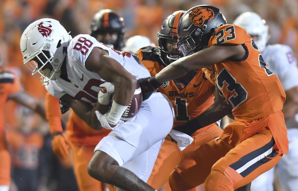 Oregon State's Ryan Cooper Jr. attempts to strip the ball from Washington State's De'Zhaun Stribling.