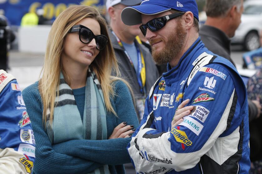 FILE - In this Sunday, Nov. 1, 2015 file photo, Sprint Cup Series driver Dale Earnhardt Jr. (88) talks with his fiance, Amy Reimann, prior to the Sprint Cup auto race at Martinsville Speedway in Martinsville, Va. NASCAR television analyst and former driver Dale Earnhardt Jr. was taken to a hospital after his plane crashed in east Tennessee. (AP Photo/Steve Helber, File)
