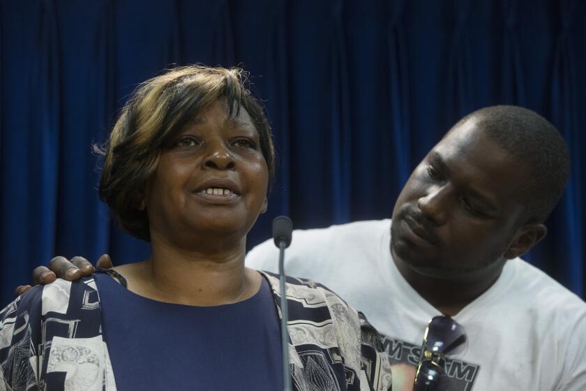 Audrey DuBose, mother of Samuel DuBose, is comforted by her son Aubrey as she speaks to the media after murder and manslaughter charges against University of Cincinnati police officer Ray Tensing were announced for the traffic stop shooting death of her son Samuel DuBose, Wednesday, July 29, 2015, in Cincinnati.