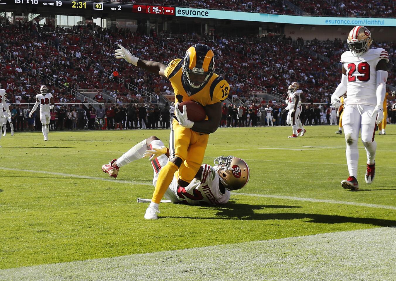Rams wide receiver Brandin Cooks (12) catches a 19-yard touchdown pass against San Francisco 49ers cornerback Ahkello Witherspoon (23) in the first half at Levi's Stadium on Sunday in Santa Clara.