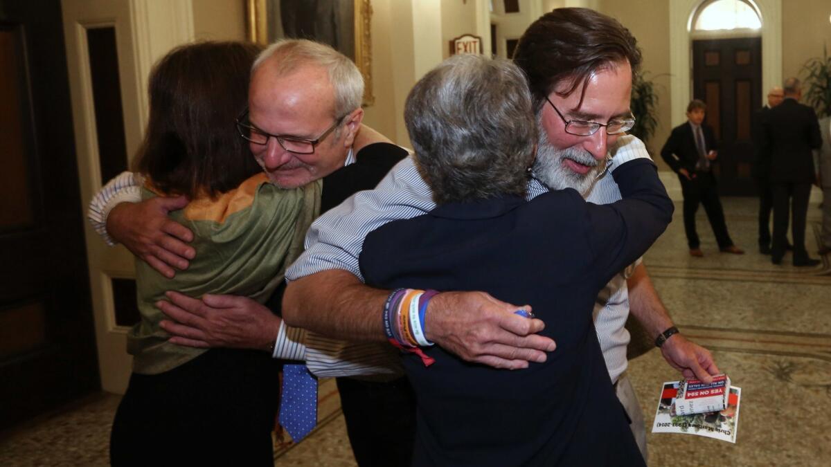 After the state Senate approved a gun removal bill in 2014, Richard Martinez, right, and Robert Weiss, who each lost a child in the Isla Vista mass shooting, celebrate with Sens. Nancy Skinner, left, and Hannah-Beth Jackson.