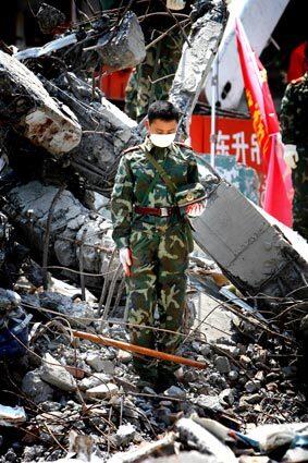 A Chinese soldier observes three minutes of silence in the rubble of a school in earthquake-hit Beichuan County, Sichuan province.