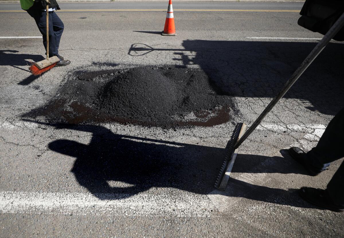 A city of San Diego crew repairs a pothole on Gilman Drive in La Jolla on Jan. 19.