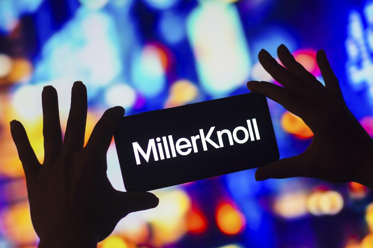 A photo illustration of a smartphone screen displaying the word "MillerKnoll"