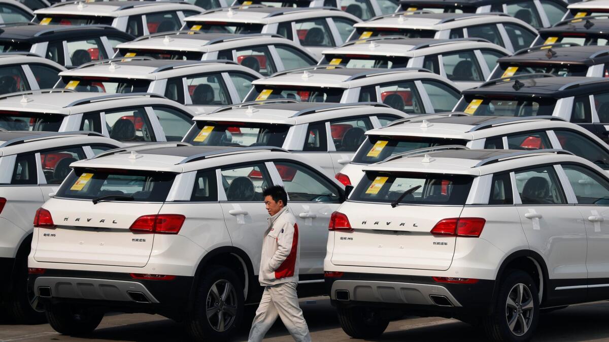 A worker walks past Haval SUV models parked outside the Great Wall Motors assembly plant in Baoding, China, on Feb. 19.