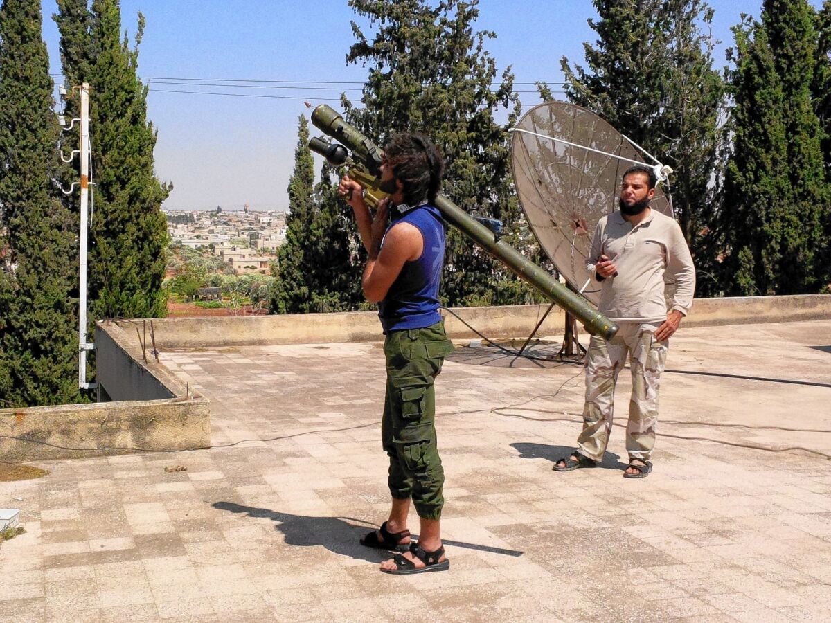 Malik Abu Iskandaroon, a rebel fighter with the Western-backed Harakat Hazm, stands on the roof of the group's air force headquarters with a Russian-made Igla anti-aircraft missile trying to target a Syrian government plane.