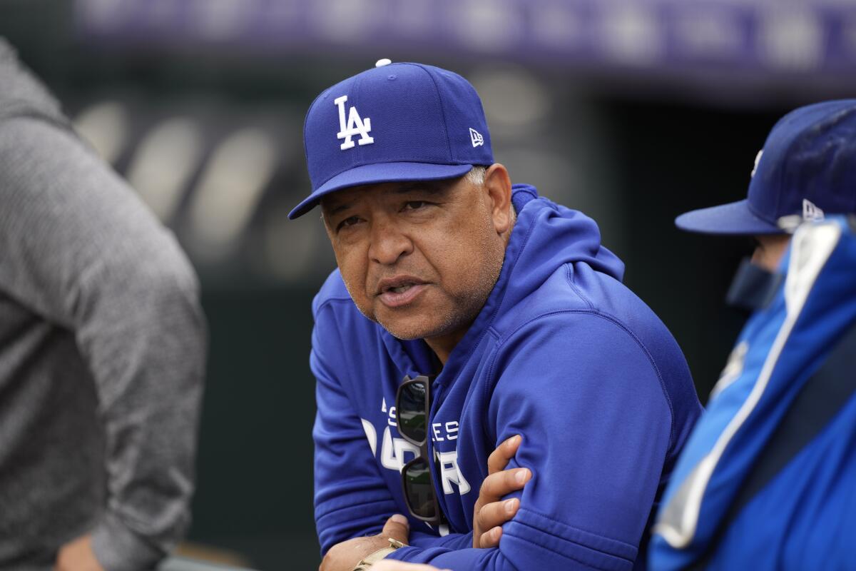 Dodgers manager Dave Roberts watches as players warm up for a game against the Rockies