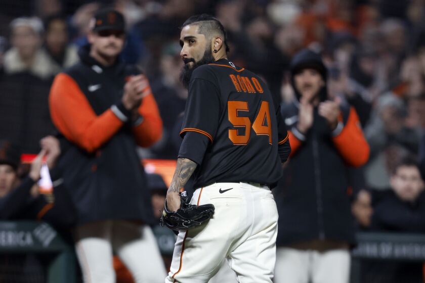 San Francisco Giants pitcher Sergio Romo (54) walks back to the dugout after being removed during the seventh inning of a spring training baseball game against the Oakland Athletics in San Francisco, Monday, March 27, 2023. (AP Photo/Jed Jacobsohn)