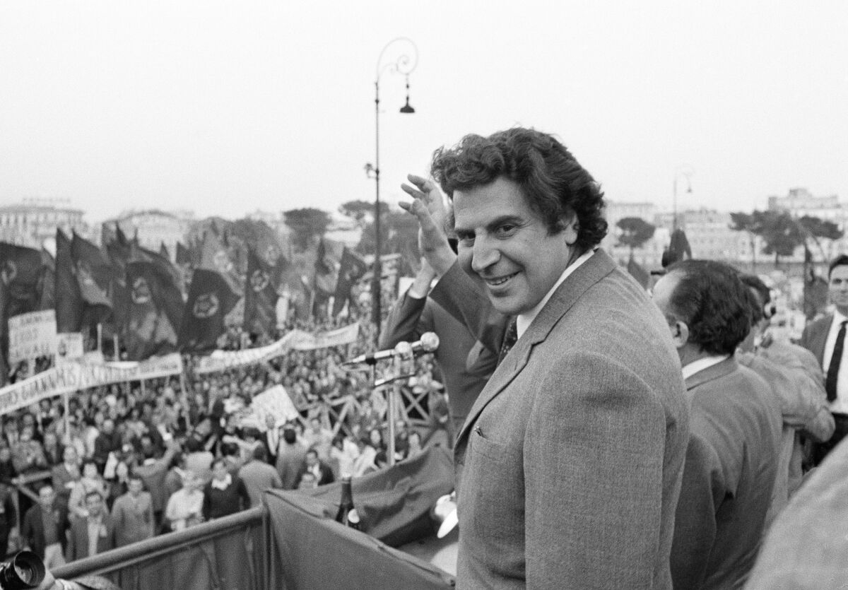 Mikis Theodorakis waves to a cheering crowd in 1970.
