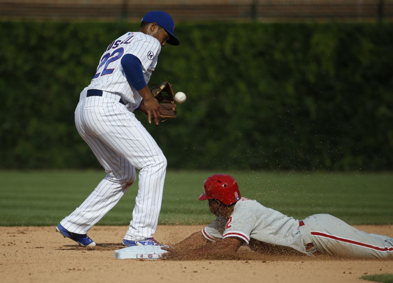 Cubs second baseman Addison Russell attempts to tag out Philadelphia Phillies left fielder Ben Revere.