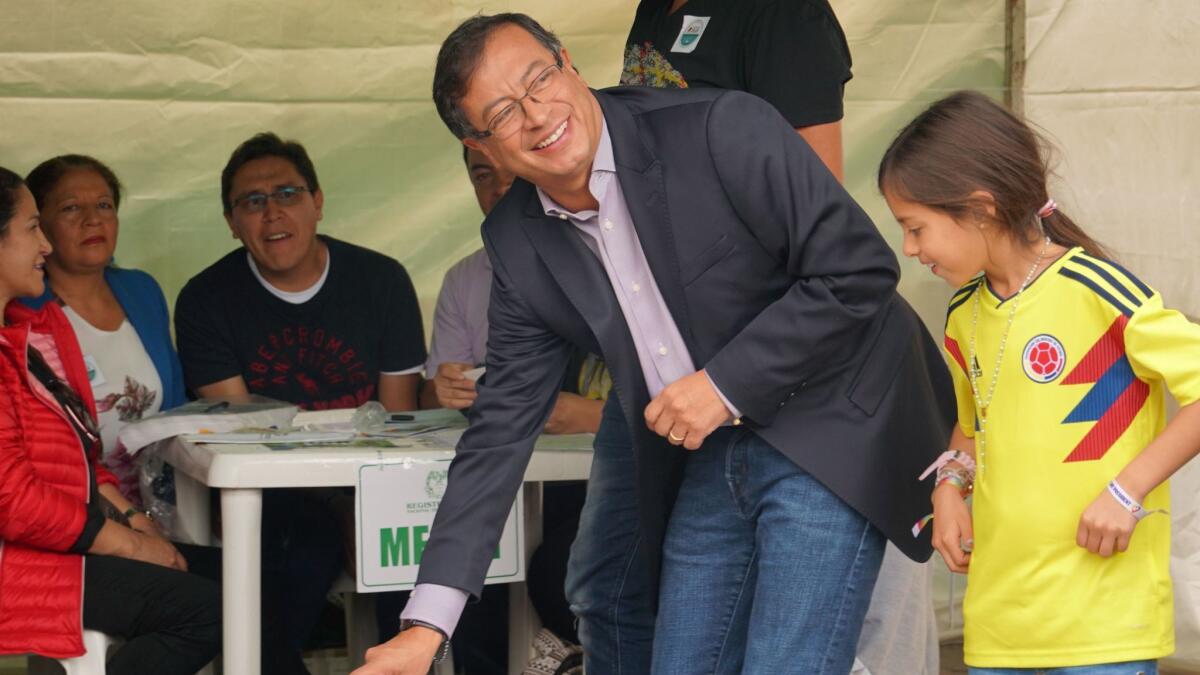 Accompanied by one of his children, Colombian presidential candidate Gustavo Petro votes in Bogota, the capital, on May 27, 2018.