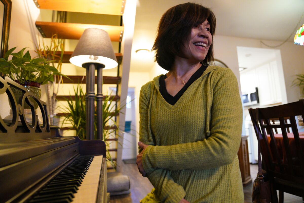 At her home in Santee, Carmen Kcomt relaxes playing the piano after a day at the office. 