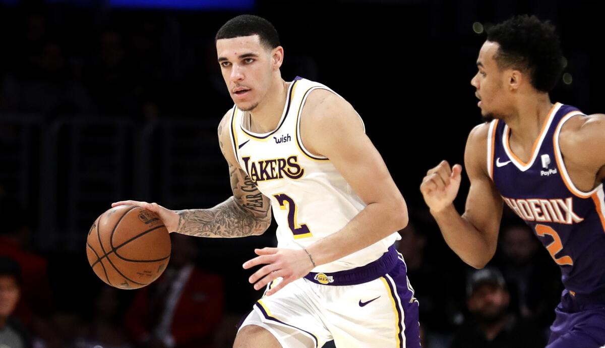 Lakers guard Lonzo Bal drives past Suns guard Elie Okobo on a fastbreak during their game Sunday at Staples Center.