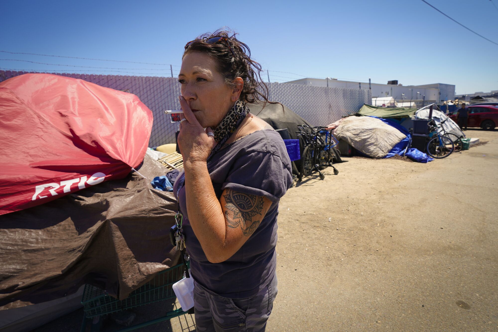 Tara Stamos-Buesig walks down a row of tents offering to test drugs