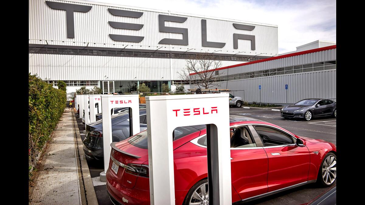 Cars charge at stations outside Tesla's factory in Fremont.