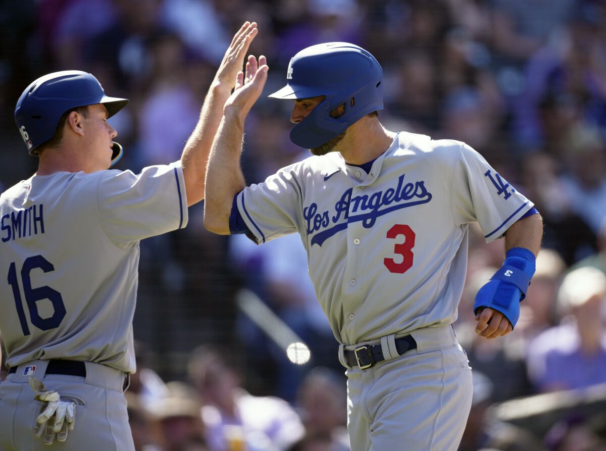 Dodgers catcher Will Smith congratulates Chris Taylor after they both score on a single hit by Gavin Lux.