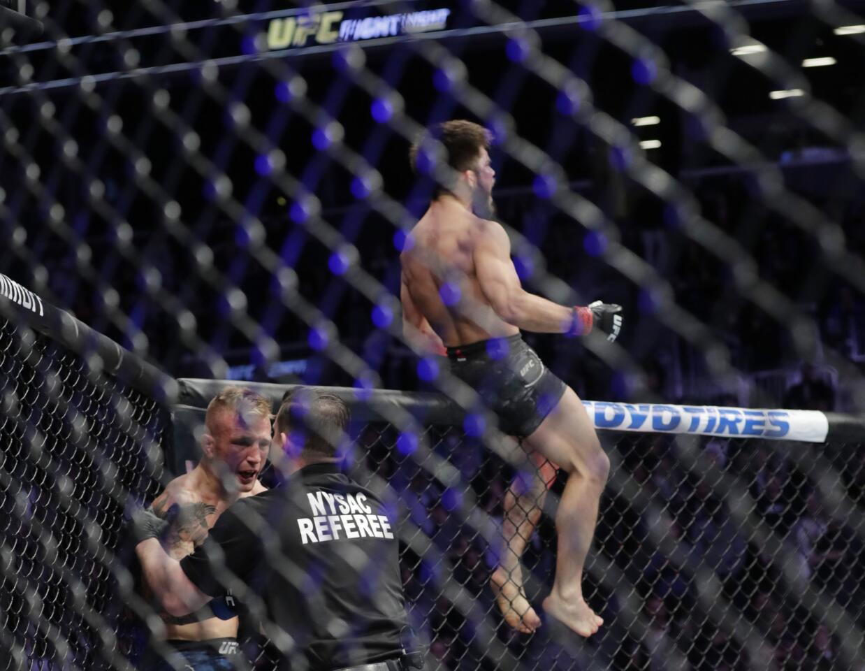 Henry Cejudo, right, celebrates as TJ Dillashaw argues with the referee after the flyweight mixed martial arts championship bout at UFC Fight Night was stopped in the first round early Sunday, Jan. 20, 2019, in New York. Cejudo won. (AP Photo/Frank Franklin II)