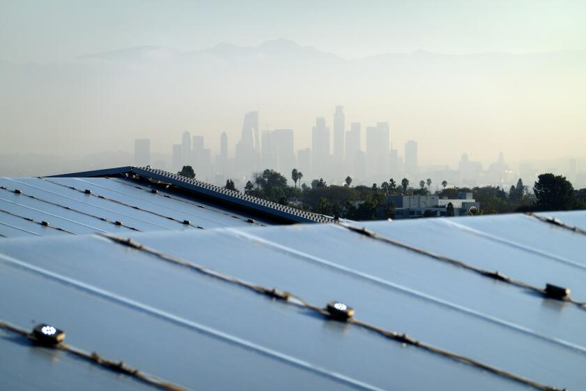 INGLEWOOD, CA - SEPTEMBER 16: The downtown skyline is just visible through the morning haze as seen from top of SoFi Stadium in Inglewood, CA. The roof is made of 75,000 square meters of a fluoropolymer film. It's design allows it to be cleaned by the rain, but since Los Angeles doesn't see a lot of rain, professional window washers are used. Their job is to clean up the deadspots - places where water hasn't fully drained allowing pockets of dirt to build up. Photographed in SoFi Stadium on Friday, Sept. 16, 2022 in Inglewood, CA. (Myung J. Chun / Los Angeles Times)