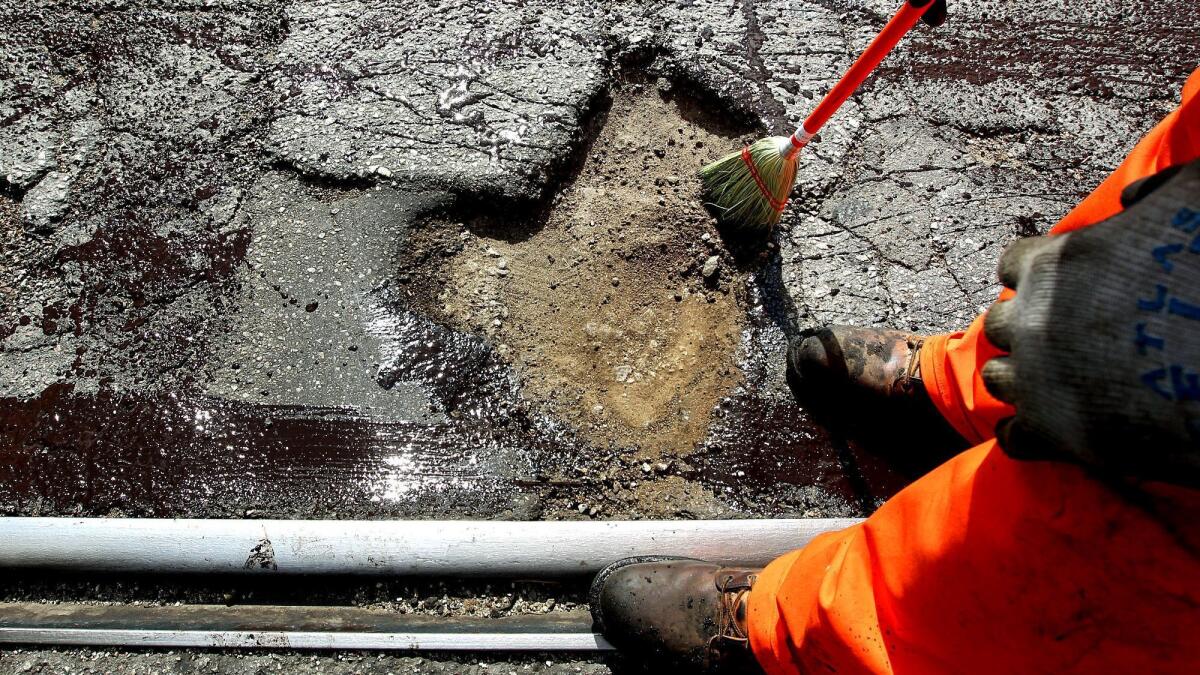 Los Angeles city workers fill a pothole on Alameda Street in 2011.