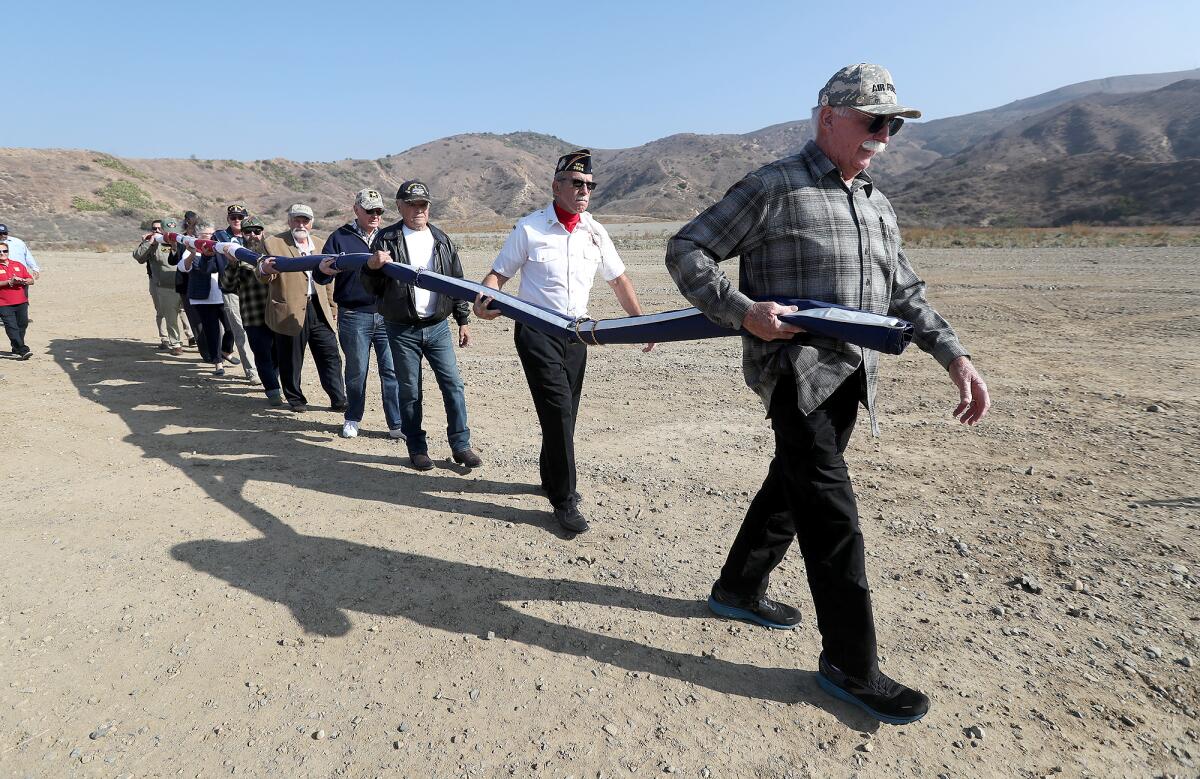 Veterans and local city officials carry "Flag One" at the proposed veteran's cemetery site in Anaheim Hills.