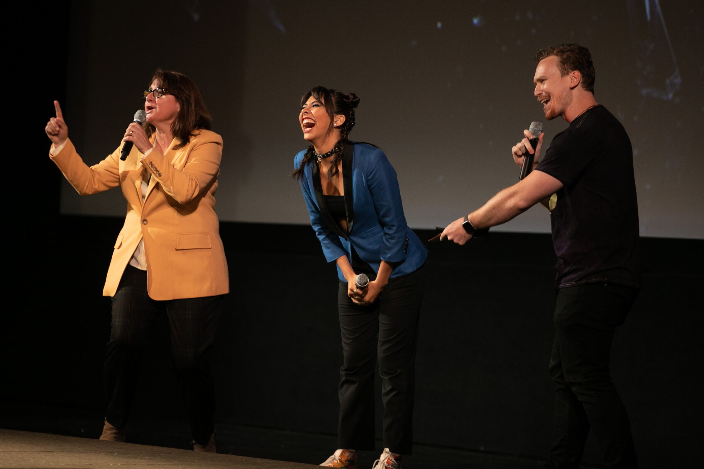 Three people speak from the El Capitan stage at the Hollywood premiere of "Doctor Strange in the Multiverse of Madness."