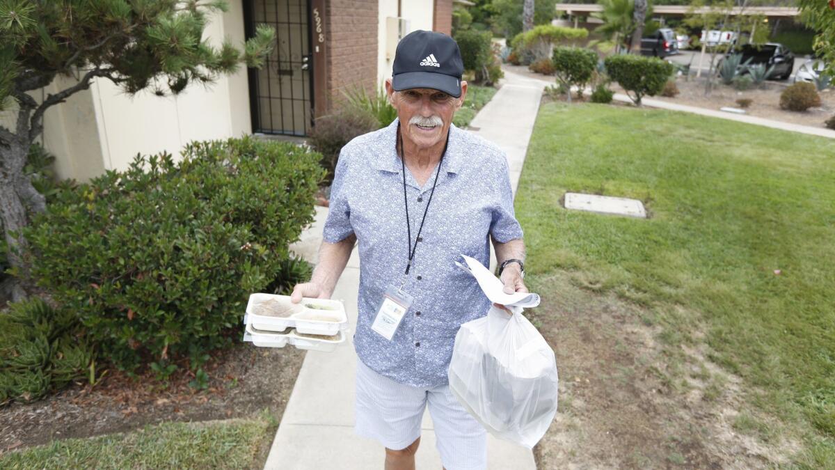 Peter Graham, voluntario del Servicio Familiar Judío, entrega las comidas a un cliente en University City. JFS proporciona 65,000 comidas al año en el área de San Diego.