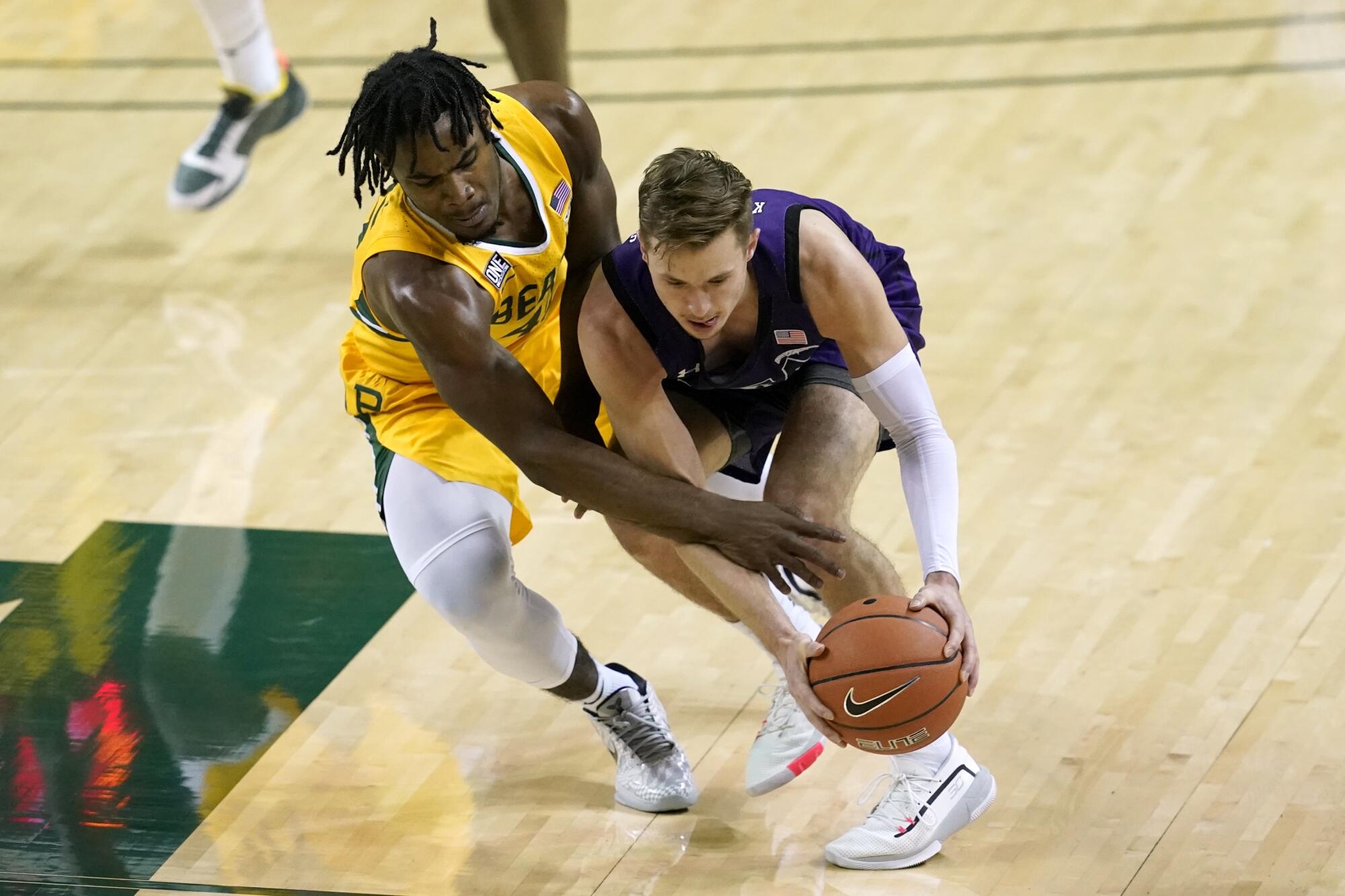 Baylor guard Davion Mitchell, left, attempts to steal the ball away from Stephen F. Austin guard David Kachelries.