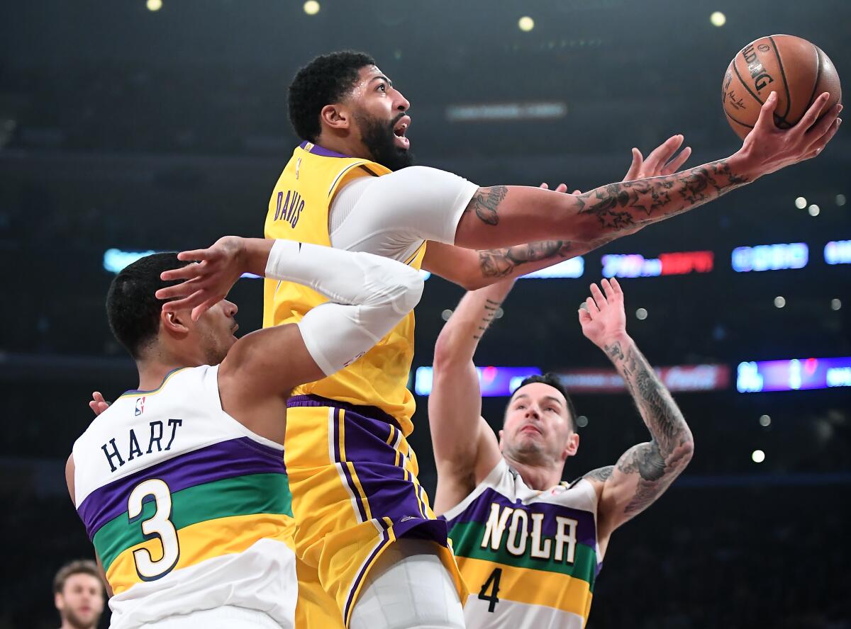 Lakers' Anthony Davis drives to the basket between New Orleans Pelicans' Josh Hart (3) and J.J. Redick in the first quarter at Staples Center on Tuesday.