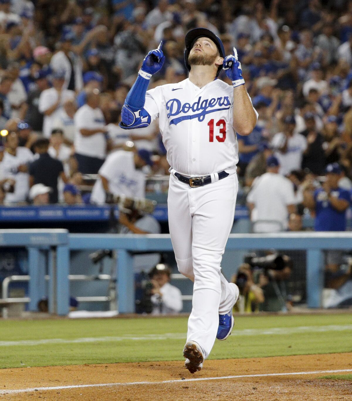 Max Muncy looks and points to the sky while running the bases