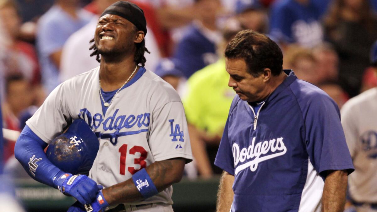 Dodgers shortstop Hanley Ramirez grimaces in pain after a pitch hit his left hand during the ninth inning of the team's 4-3 victory over the St. Louis Cardinals on Sunday night.