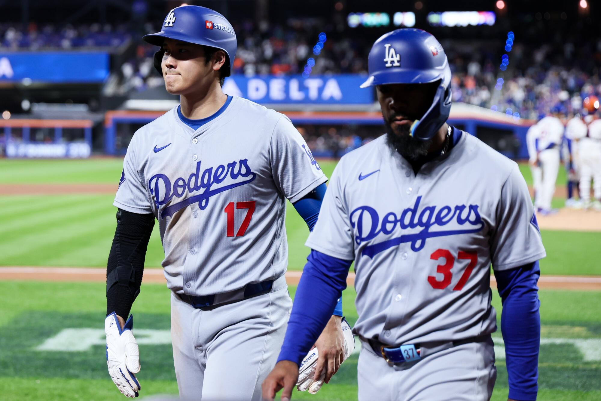 Shohei Ohtani, left, and Teoscar Hernandez walk toward the dugout during the fourth inning against the Mets on Friday night.