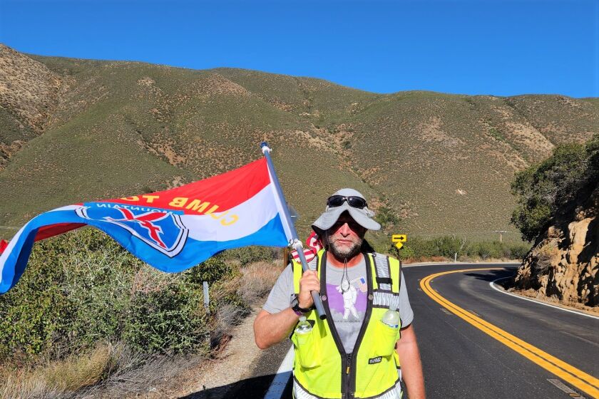 Kenny Mintz walked up Banner Grade toward Julian with a flag honoring his U.S. Army infantry battalion in Afghanistan in 2011