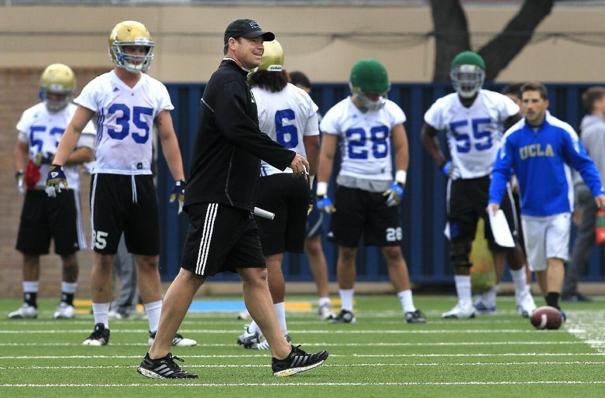 UCLA Coach Jim Mora watches his team practice during spring drills last week.